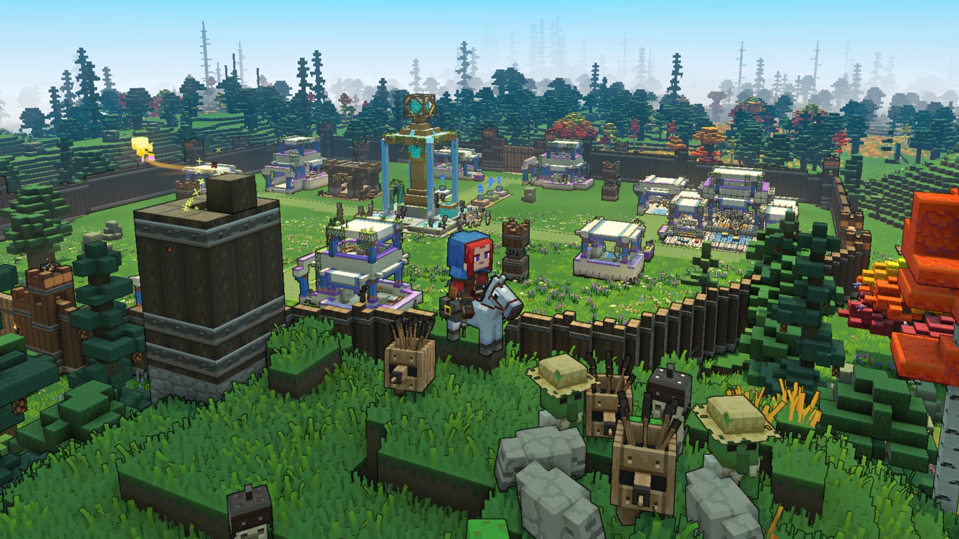 Le joueur de Minecraft Legends sur une monture se tient sur une colline herbeuse surplombant une base avec des murs en bois et plusieurs structures à l'intérieur.