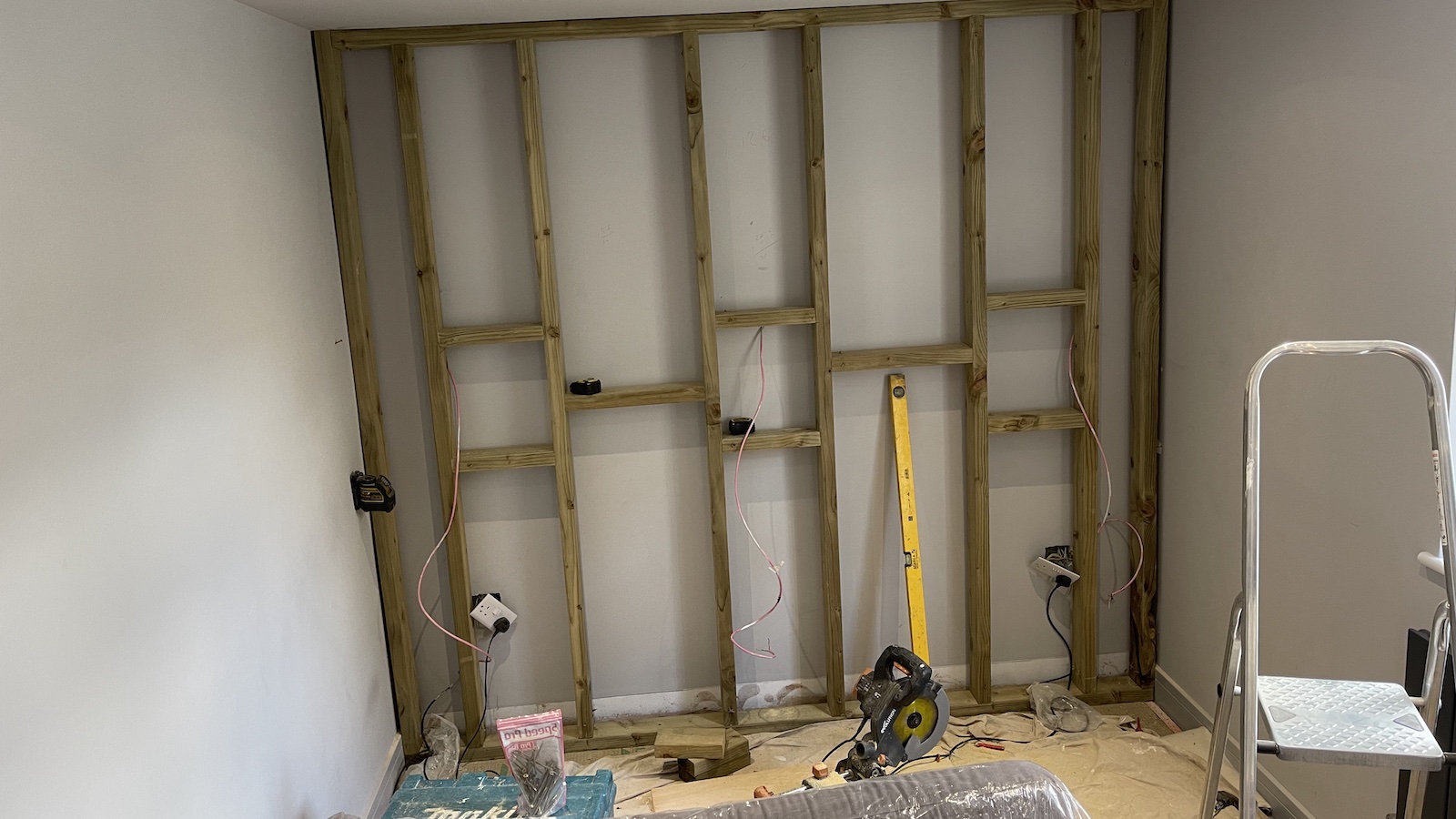 A photograph of a wall with joists exposed, read for a false wall to be added