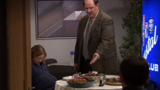 Kevin presenting his feast of food to Pam, who's cringing from labor pains in The Office