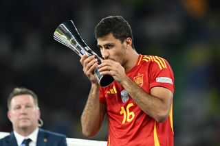 Rodri celebrates with his Player of the Tournament trophy after helping Spain win Euro 2024.