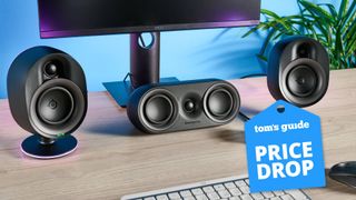 SteelSeries Arena 9 speaker setup on table with monitor and keyboard with Tom's Guide Price Drop badge