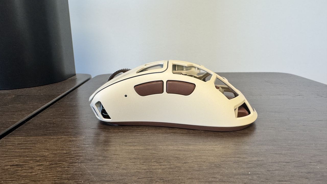 The Pulsar Feinmann F01 Noctua Edition gaming mouse on a wooden desk, from the left hand side