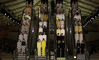Four escalators with models stnading on them