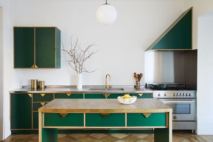 green and gold kitchen with triangular gold kitchen handles