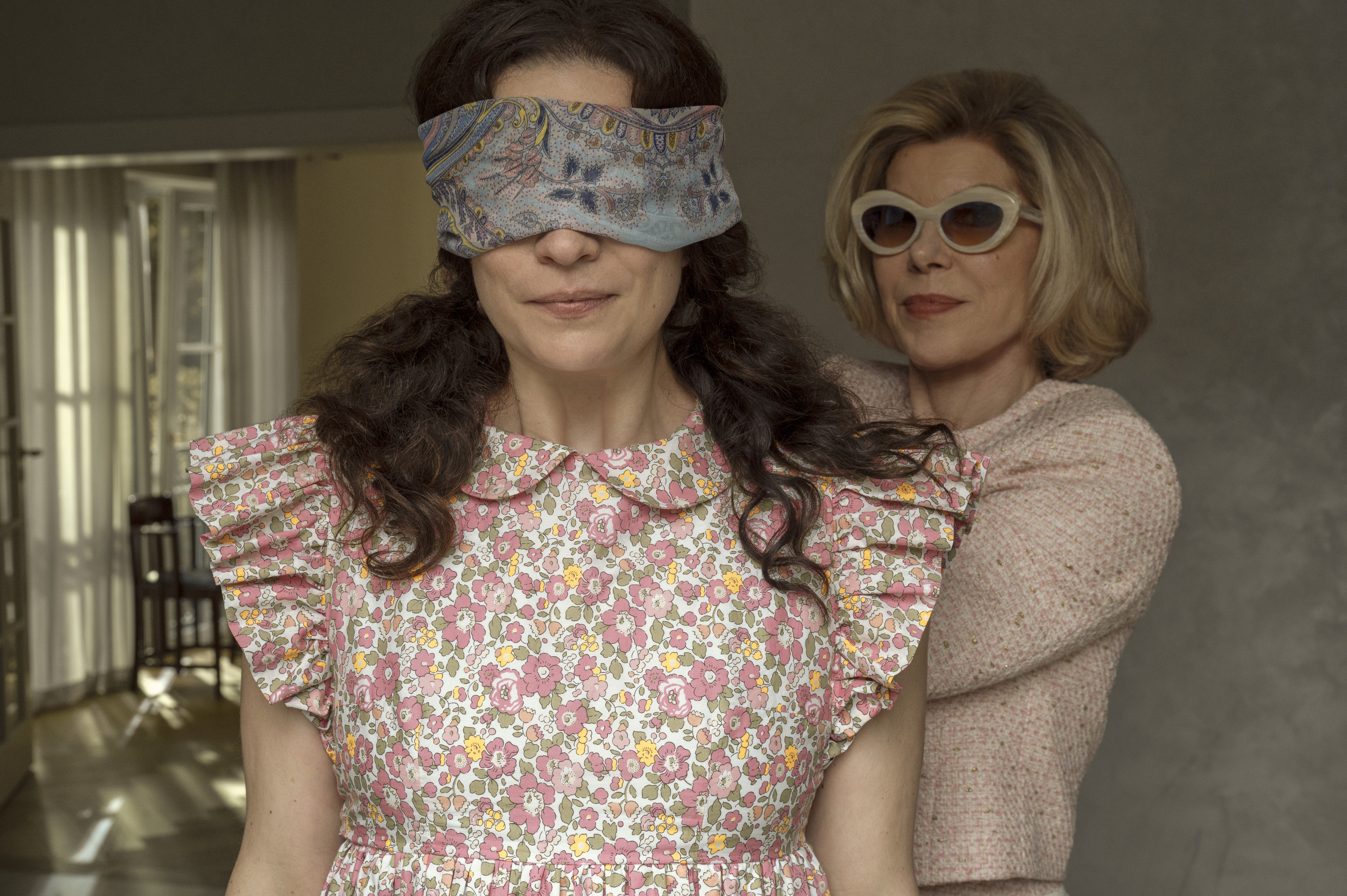 annie murphy is guided in a blindfold by chrstine baranski in a still from nine perfect strangers season 2
