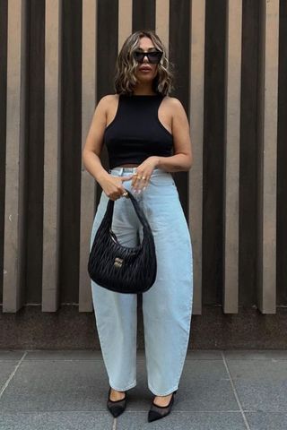 Erin Foley wearing crop top and barrel leg jeans