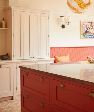 Kitchen island seating in red, rest in pale pink, artwork, lighting