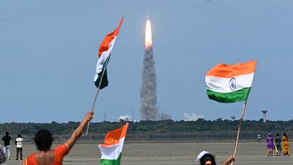 People waving Indian flags at launch of Chandrayaan rocket