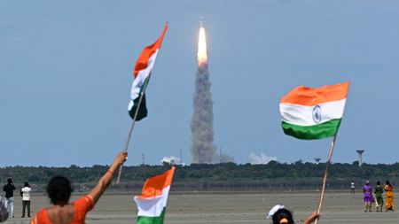 People waving Indian flags at launch of Chandrayaan rocket