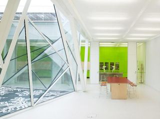 Bright white underground classroom with bright green feature wall.