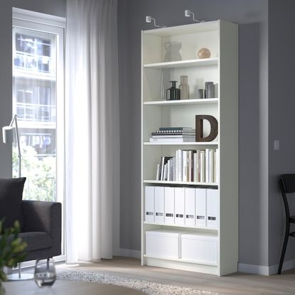 IKEA BILLY bookcase in white, with a window next to it and a black armchair to the left