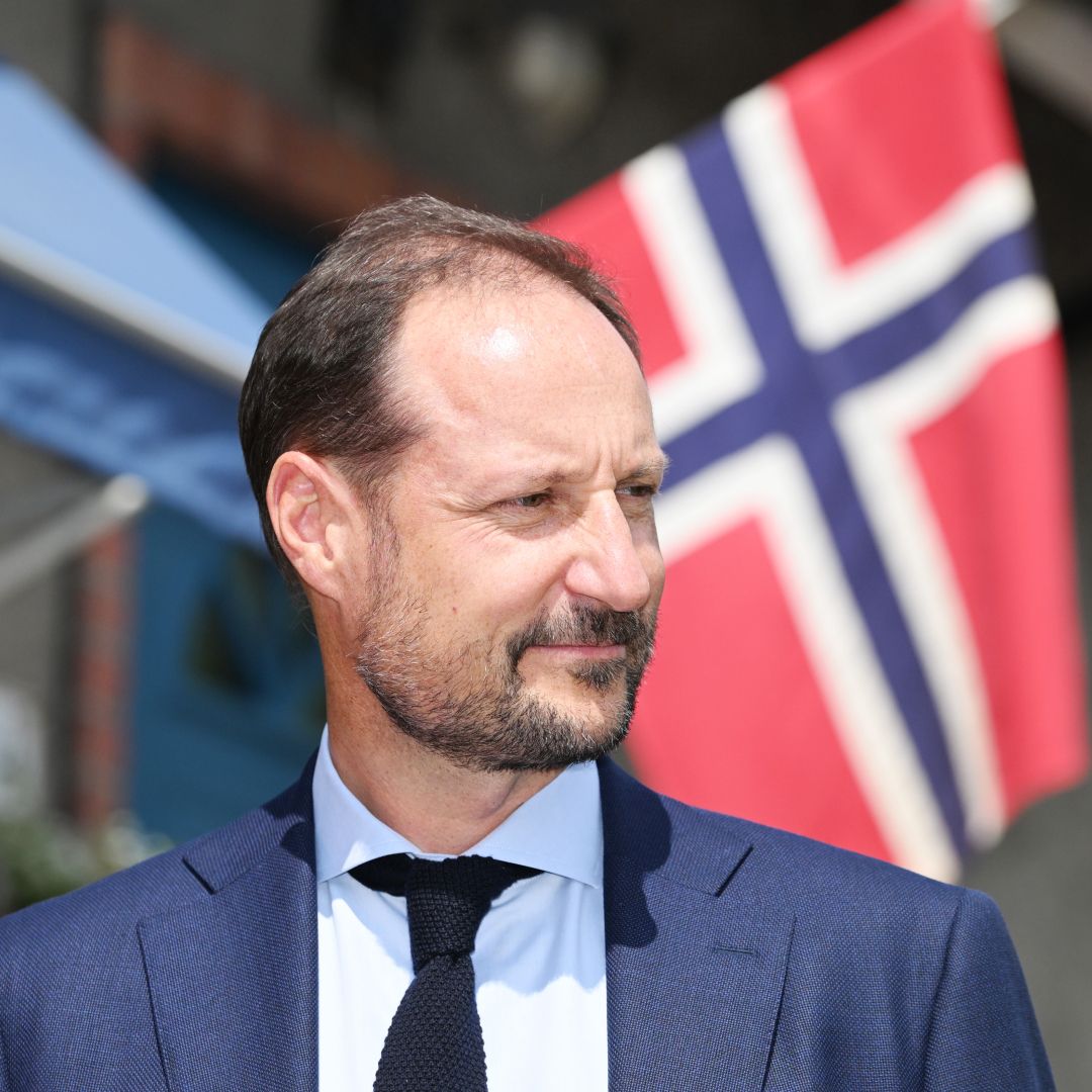Crown Prince Haakon standing in front of a Norwegian flag and Princess Martha Louise and Durek Vurett on the red carpet