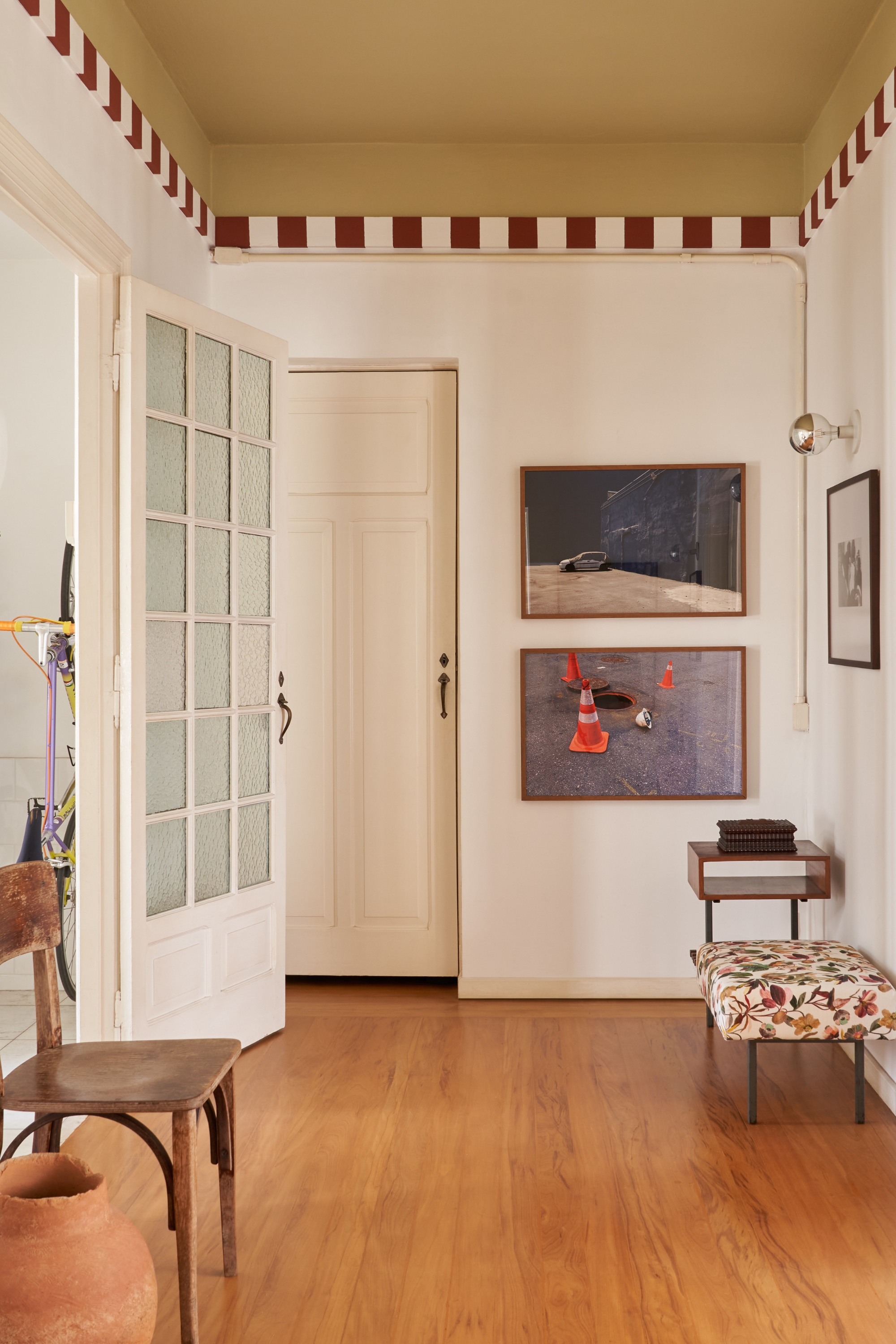 Image of a white open concept room. The ceiling is painted in an ochre yellow with a red and white stripe trim.