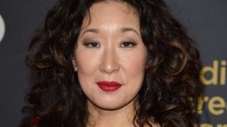 Sandra Oh wearing understated grey makeup with red lipstick