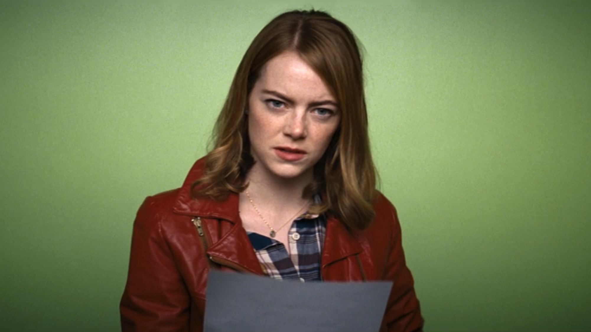 Emma Stone in red leather jacket with green screen behind her for an audition in La La Land 