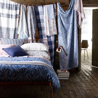 wooden room with blue beddings and lamp