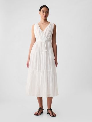 a model wears a white V-neck pleated midi dress