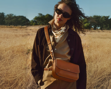Woman wearing Aspinal bag in a field