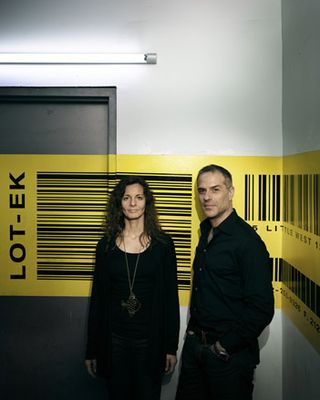 Architects Lok-Et stood in front of a yellow barcode wall