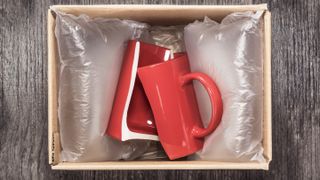 Broken red mug in box