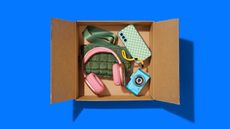 An open box with headphones, camera and other assorted items on a blue background.