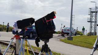 More than a dozen photographers set up cameras only a few hundred feet from the Atlas V rocket that is set to launch today (March 12). To protect the cameras from heat and rain, the photographers build their own protection devices; here, cameras are protected by white cloth, black plastic boxes, poster board and garbage bags.