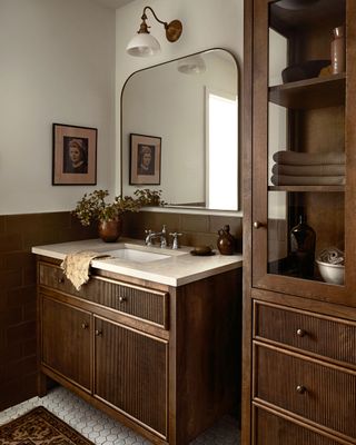 a bathroom with a wood vanity and brown tiles