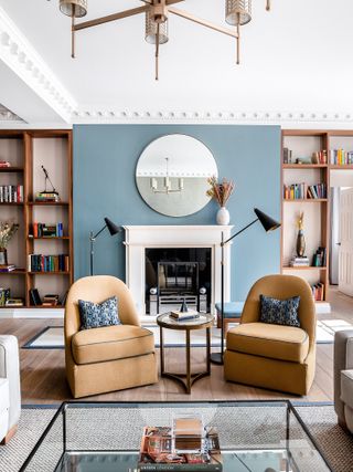 Blue wall, white fireplace, yellow chairs