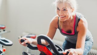 Woman smiles as she exercises on an exercise bike