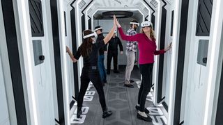 people wearing VR glasses walk inside a white hallway