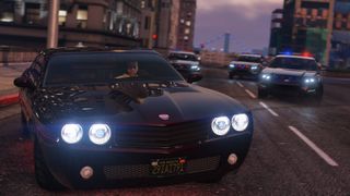 A character in GTA 5 driving a car, with three police cars behind him.