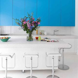 kitchen with blue cupboards and bar stools