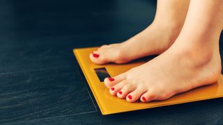 Woman weighing herself on bathroom scale
