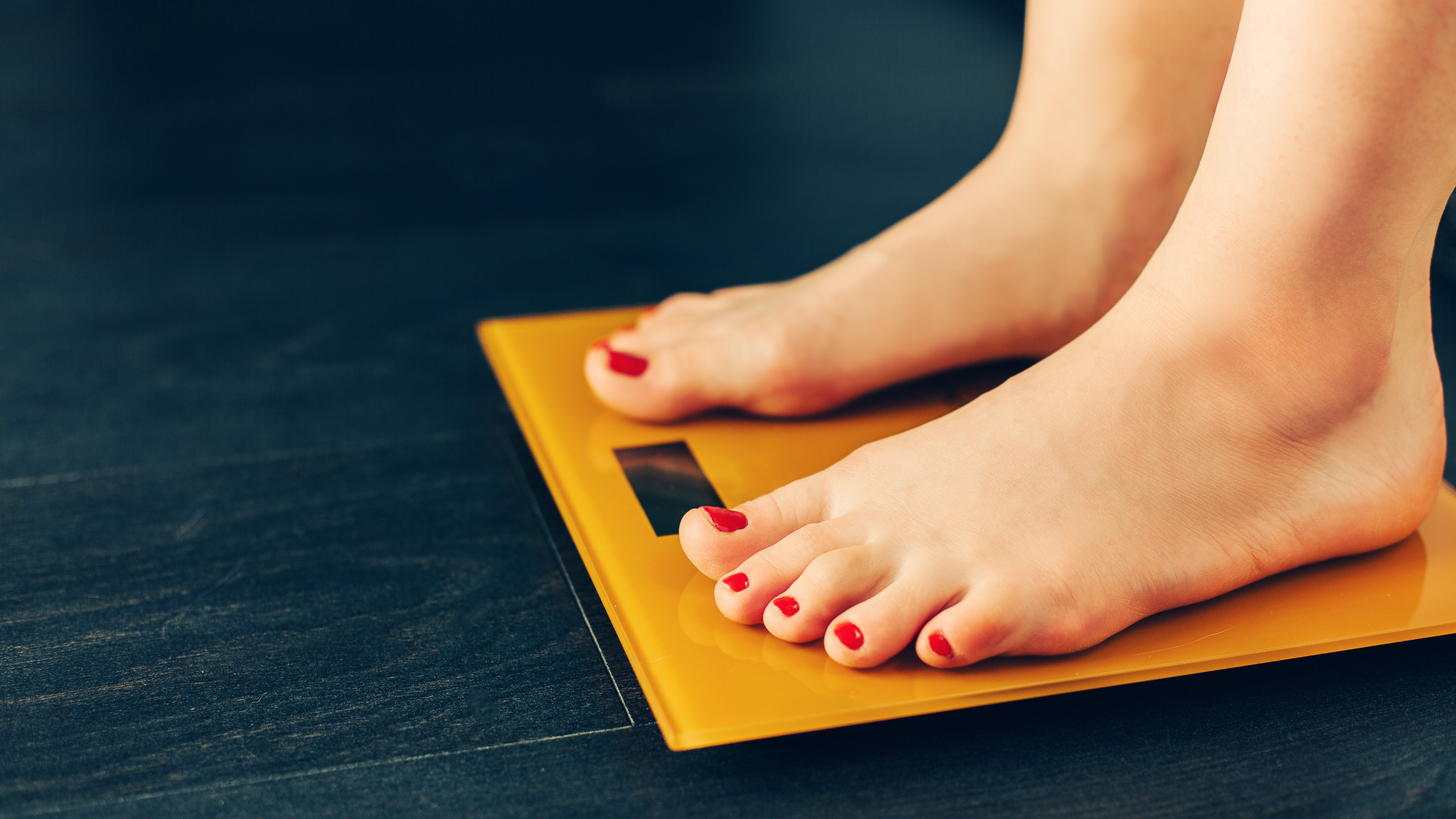 Woman weighing herself on bathroom scale