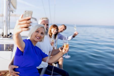 Happy friends on a yacht drinking champagne