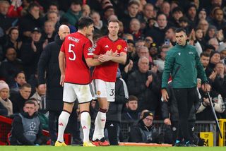 Harry Maguire of Manchester United is substituted for Jonny Evans during the UEFA Champions League match between Manchester United and FC Bayern München at Old Trafford on December 12, 2023 in Manchester, England.