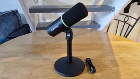 The Shure MV6 USB Gaming Microphone on a table top, with included stand and USB cable