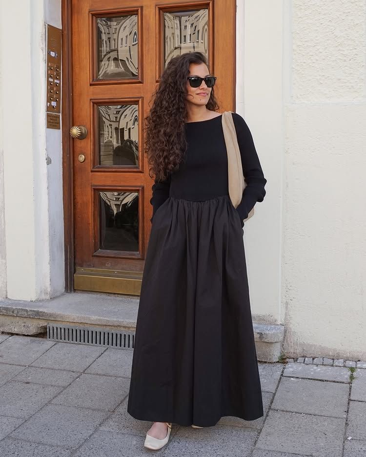 @courtney__flowers wears a black two-part dress with Mary Jane shoes and a slouchy shoulder bag
