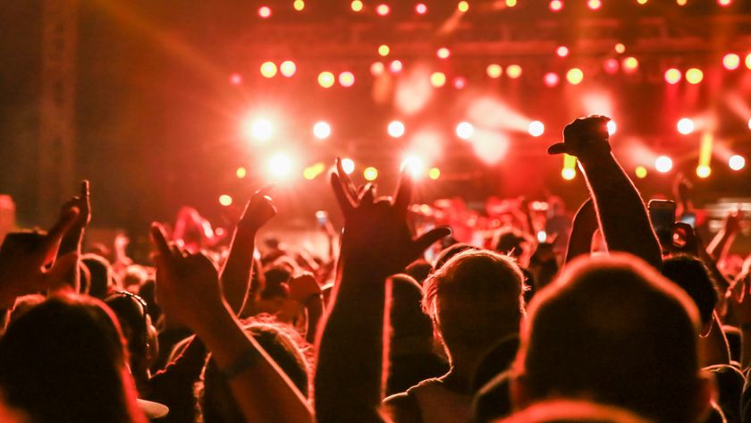 Concert crowd arms raised in mosh pit