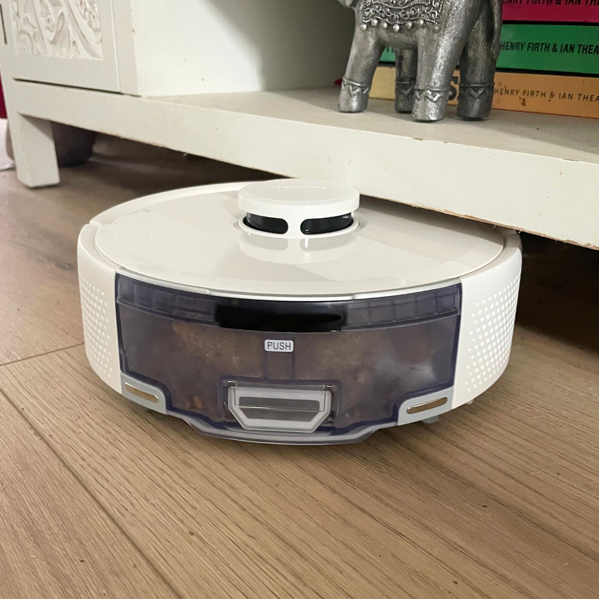 SwitchBot K11+ Robot Vacuum Cleaner with Mop bumping into low furniture