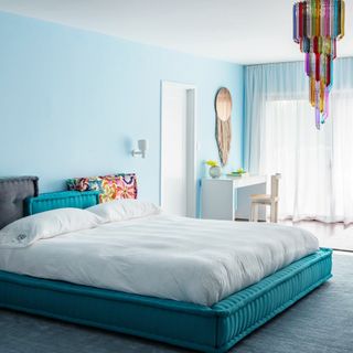 Bedroom with blue walls and multicoloured Murano glass chandelier