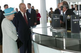 Queen Elizabeth II and Prince Philip, Duke of Edinburgh watch a pint of Guinness being poured as they visit the Guinness Storehouse on May 18, 2011 in Dublin, Ireland