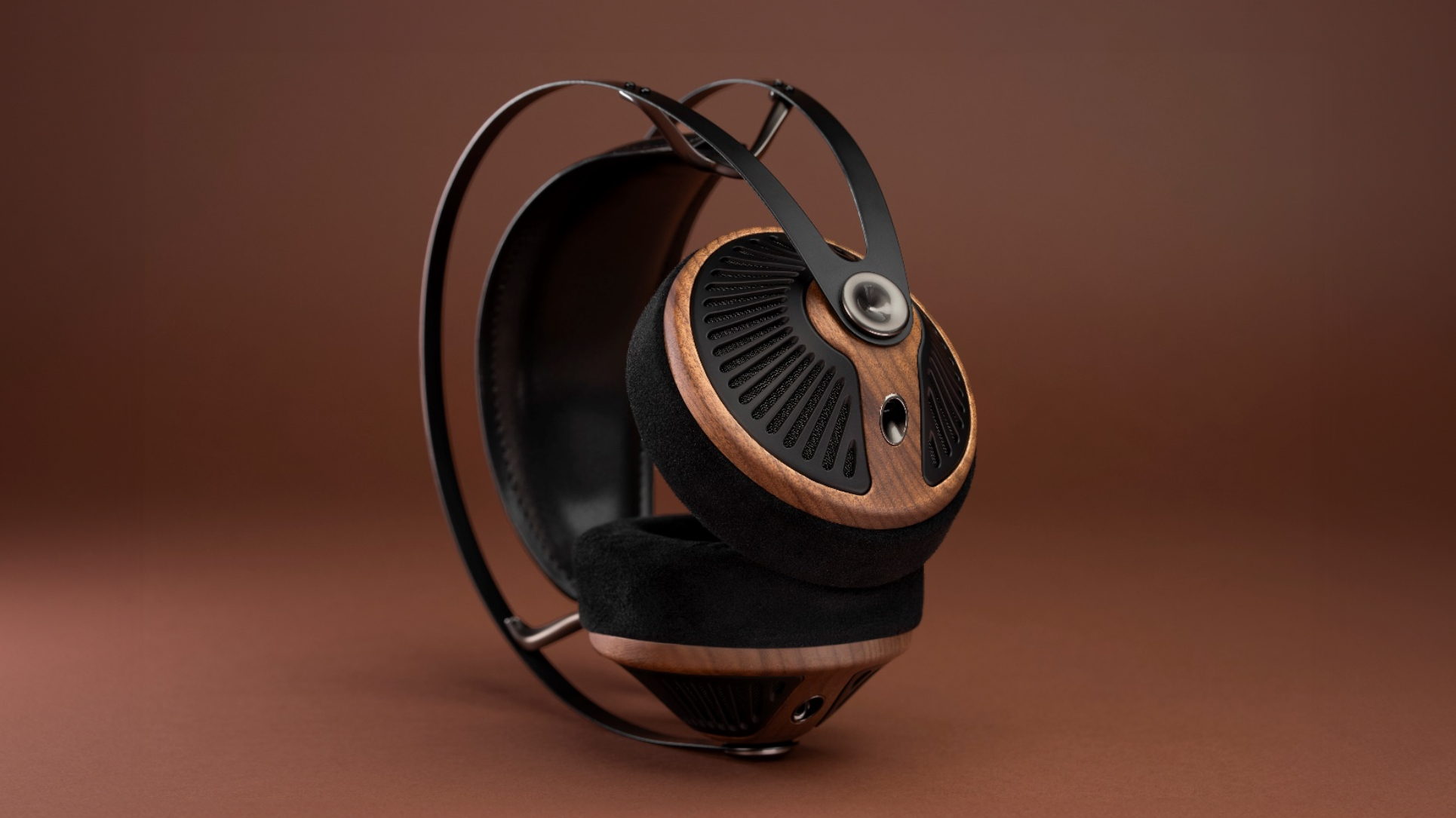 A pair of Meze Audio 105 Silva headphones on a brown background