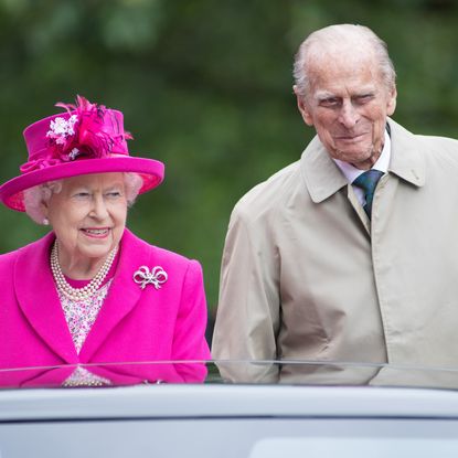 Queen Elizabeth II wears a bright pink suit with matching hat and Prince Philip smirks during The Patron's Lunch celebrations for The Queen's 90th birthday at The Mall on June 12, 2016