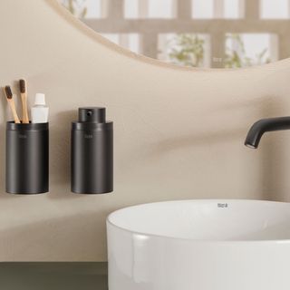 Black matt bathroom accessories mounted to wall besides a basin