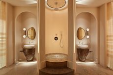 a bathroom with symmetrical layout, the shower in the center and two vanities on either side