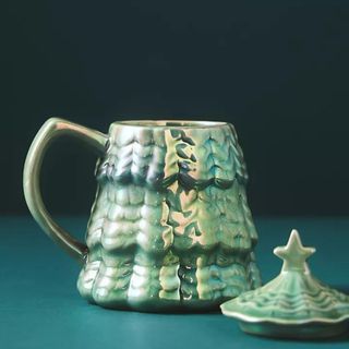 Merry Luster Tree Stoneware Mug against a blue background.