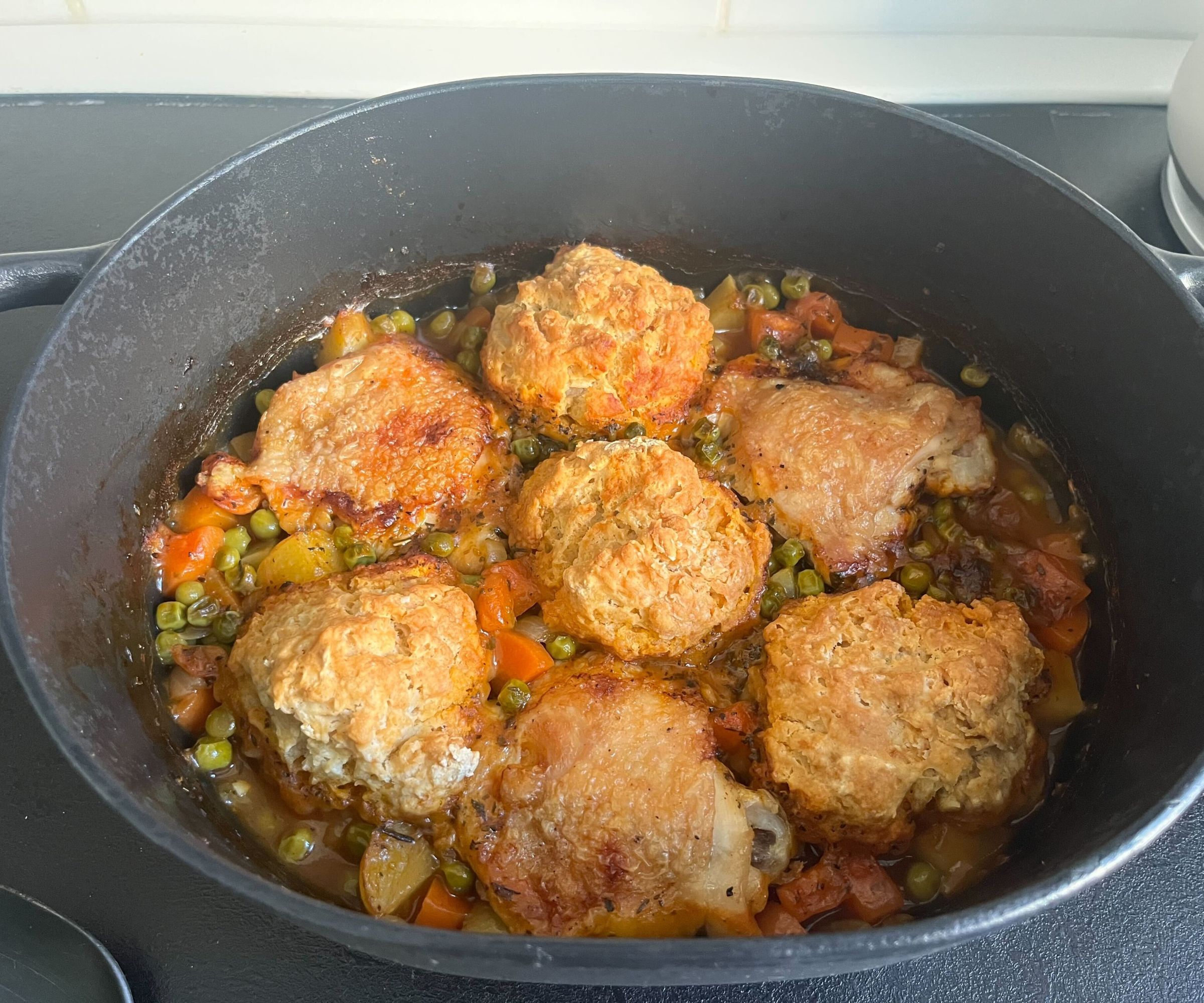 A golden chicken and dumpling casserole in a Dutch oven