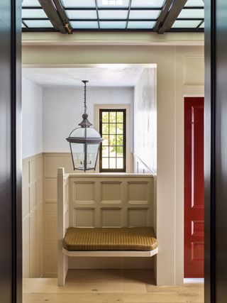 A built-in bench at the top of the steps, surrounded y wainscoting, creates a seating area out of unused space.