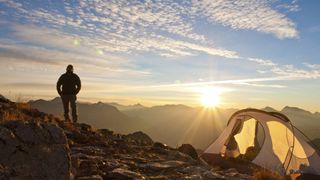 how to choose a tent: wild camper enjoying sunrise